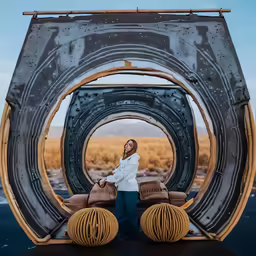 a woman posing for a photo in front of a giant mirror