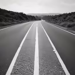 the road is empty and white and has two lines painted on it