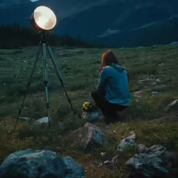 a woman is crouched down and having a light on