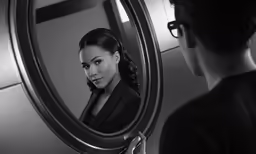 a woman is looking at herself in the mirror