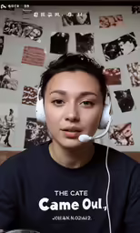 a young person wearing headphones and sitting in front of a wall