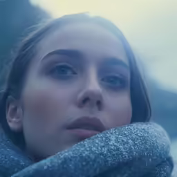 a woman wearing a scarf looking at the camera
