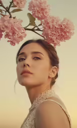 a young woman wearing a dress standing in front of flowers