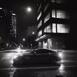 a very dark city street with a very shiny car