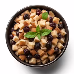 an assortment of fruits and greens are grouped together in a black bowl
