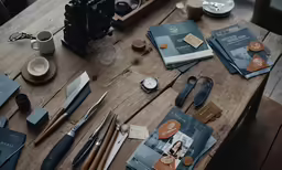 there is an old table with pens, scissors and books