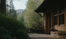 a house in the woods with a bench on the porch
