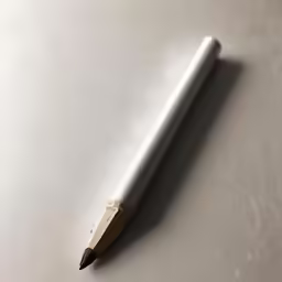 a black and white pencil is lying on a table