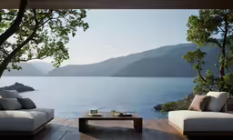 a couch, table and pillows sit on a deck next to a body of water