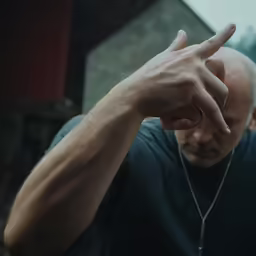 a close up of a person making a peace sign