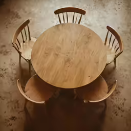 three wooden chairs are around a round table