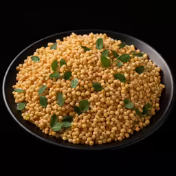 a bunch of yellow grains with green leaves on a black plate