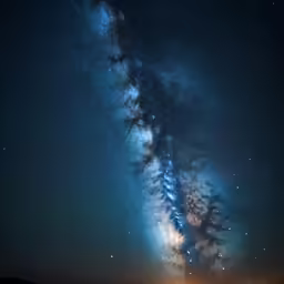 the night sky above an empty field and clouds