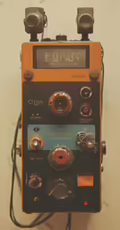 an old camera sitting on top of a piece of electronics
