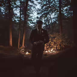 a man dressed in suit and tie walking through the woods