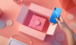 a woman holding an iphone in their hand next to pink and blue boxes
