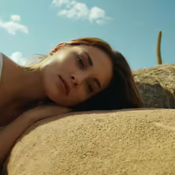 a woman is laying down on top of a rock