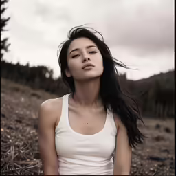 a young woman posing on top of a field