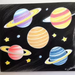 an illustration of four planets in different colors,a chalk board is decorated with various pictures of saturn and its solar system,the planets are painted on the blackboard and ready to be used,a drawing with some different planets on it,colored drawings of planets on a chalk board