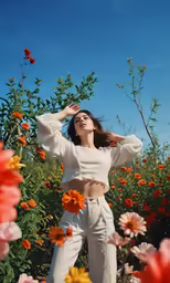 a woman standing in a field of flowers