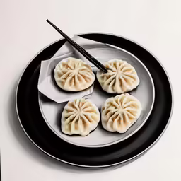 a plate of dumplings, with chopsticks on top