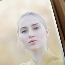 a woman wearing a yellow shirt is looking out of the window