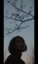 a close up of a person standing under a tree