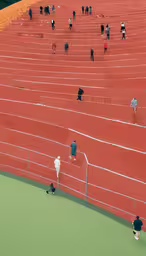 a person taking pictures on the tennis court,a group of people playing tennis on red courts