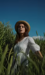 a woman in white dress standing near a large field