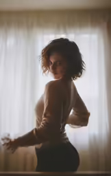a girl that is standing in front of some curtains