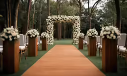 a walkway with some wooden chairs next to flower arrangements