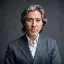 the man with gray hair wearing a black suit