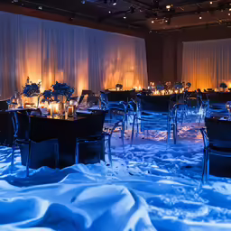 a restaurant set up with winter lights in the background