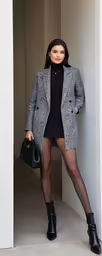 the woman is posing next to the wall