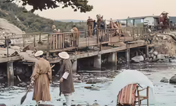 a group of people walking on a bridge over water