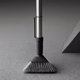 a black and white photo of a broom sitting on the floor