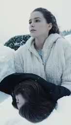 two people sitting in the snow wearing coat