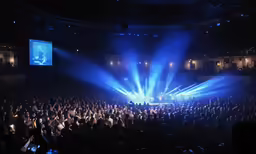 an empty auditorium with a wide shot of the stage, and stage lights