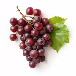 a bunch of grapes and green leaves sit on a white surface