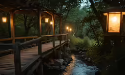 a wooden bridge with lantern lights over a river
