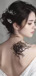 a woman with her back tattoo done in black ink