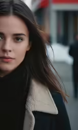 a woman looks to the side while on a street corner