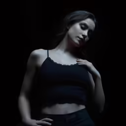 woman in black crop top and jeans, standing up