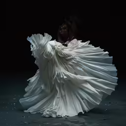 a woman with a white dress on posing in the dark