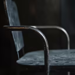 a grey, old metal chair that is rusted with a black fabric