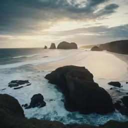 rocky coastline with waves coming in to shore on cloudy day