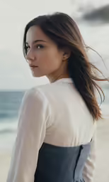 a young woman in a dress is staring into the distance