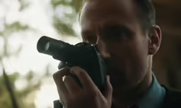 the man takes a photograph with his camera