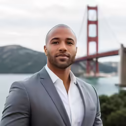 a man in a suit with the golden gate bridge in the background