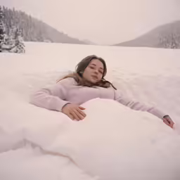 a woman is laying in the snow